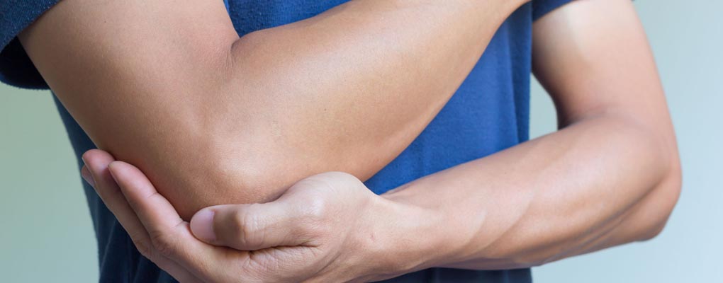 Photograph of person holding elbow because of pain